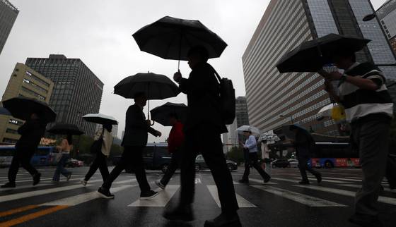 비가 내리는 15일 오전 서울 종로구 광화문 네거리에 우산을 쓴 시민들이 발걸음을 재촉하고 있다. 뉴시스