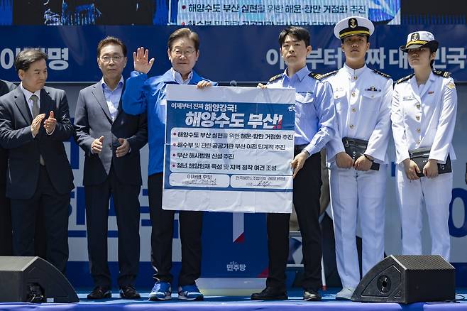 이재명 더불어민주당 대선 후보가 14일 부산 부산진구 서면에서 열린 유세에서 부산 해양수도를 위한 공약에 서명한 뒤 들어보이고 있다. 연합뉴스