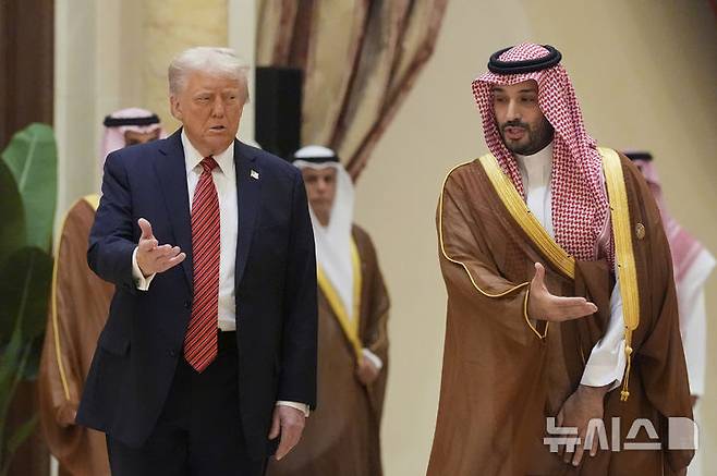 [리야드=AP/뉴시스] 도널드 트럼프(왼쪽) 미국 대통령과 무함마드 빈 살만 사우디 왕세자가 14일(현지 시간) 사우디아라비아 리야드에서 열린 걸프협력회의(GCC) 정상회의에 함께 참석해 GCC 정상들과 단체 사진 촬영장으로 향하고 있다. 2025.05.15.