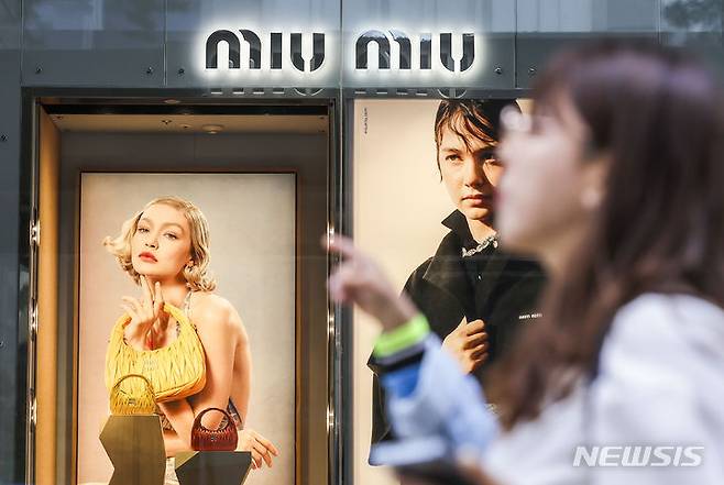 [서울=뉴시스] 정병혁 기자 = 7일 서울시내 백화점 미우미우 광고판 앞에서 시민들이 이동하고 있다.  2024.05.07. jhope@newsis.com