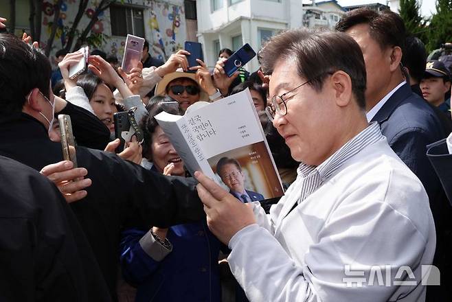 [전주=뉴시스] 조성봉 기자 = 민심을 청취하는 '경청 투어'에 나선 이재명 더불어민주당 대선후보가 7일 전북 전주시 완산구 풍남문 인근에서 시민들에게 사인을 해주고 있다. 2025.05.07. suncho21@newsis.com