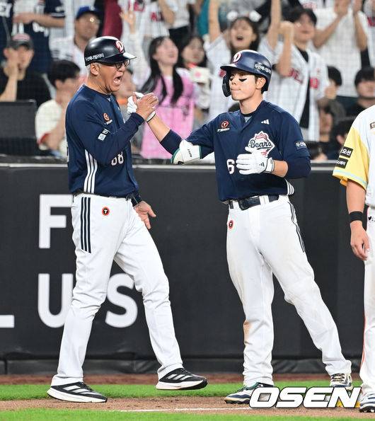 [OSEN=대전, 김성락 기자] 14일 대전 한화생명볼파크에서 ‘2025 신한 SOL Bank KBO리그’ 한화 이글스와 두산 베어스의 경기가 열렸다.이날 한화는 문동주, 두산은 잭로그를 선발로 내세웠다.8회초 1사 1루 두산 오명진이 1타점 적시 3루타를 날린 뒤 고토 코치와 하이파이브를 하고 있다. 2025.05.14 / ksl0919@osen.co.kr