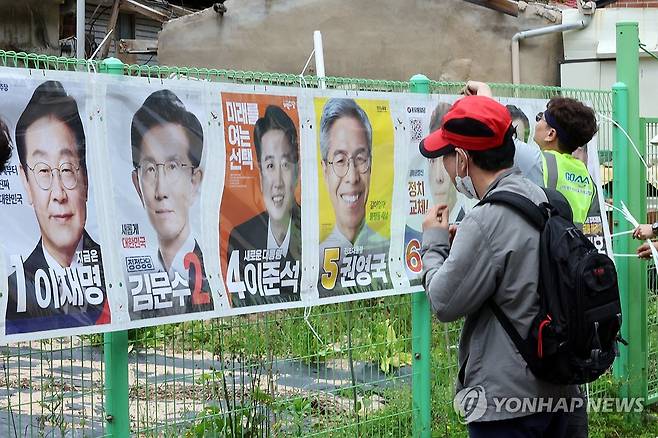 벽보 살펴보는 시민 (광주=연합뉴스) 김혜인 기자 = 제21대 대통령 공식 선거운동이 계속되고 있는 가운데 15일 광주 동구 운림동 한 골목에서 시민이 부착된 대통령 선거 벽보를 바라보고 있다. 2025.5.15 in@yna.co.kr