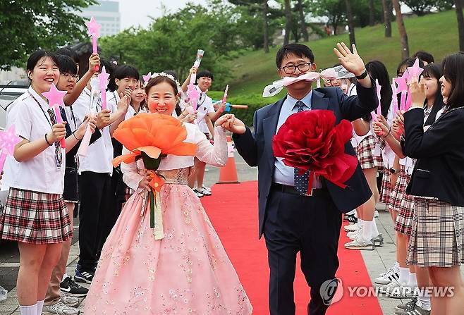 스승의날, 레드카펫 밟는 선생님들 (수원=연합뉴스) 홍기원 기자 = 스승의날인 15일 경기도 수원시 팔달구 매향중학교에서 선생님들이 학생들이 준비한 레드카펫을 밟으며 교문으로 들어가고 있다. 2025.5.15 xanadu@yna.co.kr