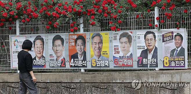 고민 깊어지는 '장미 대선' (대구=연합뉴스) 윤관식 기자 = 15일 대구 중구 남산동에서 한 유권자가 제21대 대통령 선거 벽보를 살펴보고 있다. 2025.5.15 psik@yna.co.kr