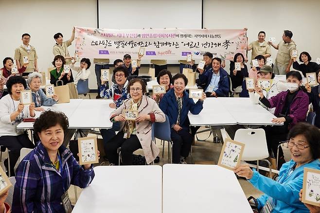 지난 15일 스타필드 시티 부천에서 진행된 압화 캘리그래피 클래스에서 '별꿈 서포터즈'와 어르신들이 기념 사진을 촬영하고 있다(신세계프라퍼티 제공).