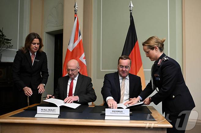 2025년 5월 15일, 독일 베를린에서 열린 트리니티 하우스 국방장관 회의에서 보리스 피스토리우스 독일 국방장관과 존 힐리 영국 국방장관이 영-독 트리니티 하우스 국방 협정 이행을 위한 양자 회담 후 문서에 서명하고 있다. 이날 회담에서 양국은 사거리 2000㎞가 넘는 심층정밀타격 무기를 공동개발하는 데 합의했다. 2025.05.15. ⓒ 로이터=뉴스1