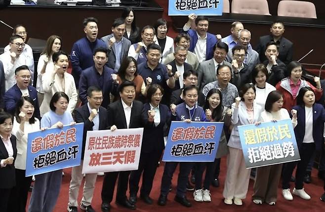 지난 9일 대만 타이베이 입법원에서 '기념일 및 국경일 시행에 관한 법률' 개정안이 통과된 뒤 이 법안을 추진한 국민당 의원들이 모여 이를 축하하고 있다. 들고 있는 팻말엔 "휴일을 국민들에게 돌려주자, 피땀 흘리는 과로는 거절한다"라는 구호가 적혀 있다./페이스북