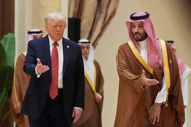 도널드 트럼프(왼쪽) 미국 대통령이 14일(현지시각) 사우디아라비아 리야드에서 열린 GCC 정상회의에서 모하메드 빈 살만 사우디 왕세자와 함께 이동하고 있다. /연합뉴스