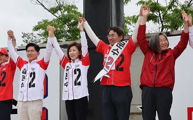 김문수 국민의힘 대통령 후보가 16일 오전 경기 화성시 동탄 센트럴파크에서 시민들에게 지지를 호소하며 공동선거대책위원장 등과 함께 손을 맞잡고 있다. 신소영 기자 viator@hani.co.kr