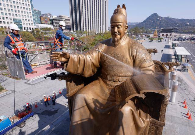 지난달 15일 서울 광화문광장에서 서울시 관계자들이 세종대왕 동상을 세척하고 있다. 연합뉴스