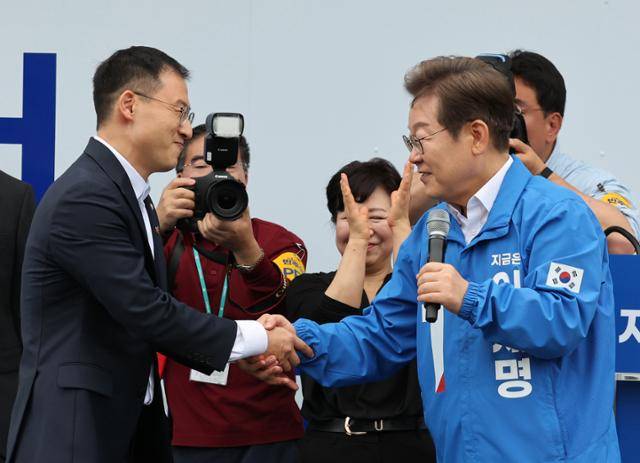 이재명(오른쪽) 더불어민주당 대선 후보가 16일 전북 익산역 동부광장 유세에서 최근 국민의힘을 탈당한 김상욱 의원과 악수하고 있다. 익산=고영권 기자