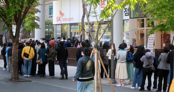 SK Telecom users wait in line to switch their SIM cards in front of a store in Jongno District, central Seoul, on April 29. [NEWS1]