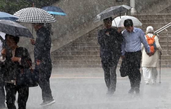 People walk in the rain near Seoul Station in central Seoul on May 16. [YONHAP]