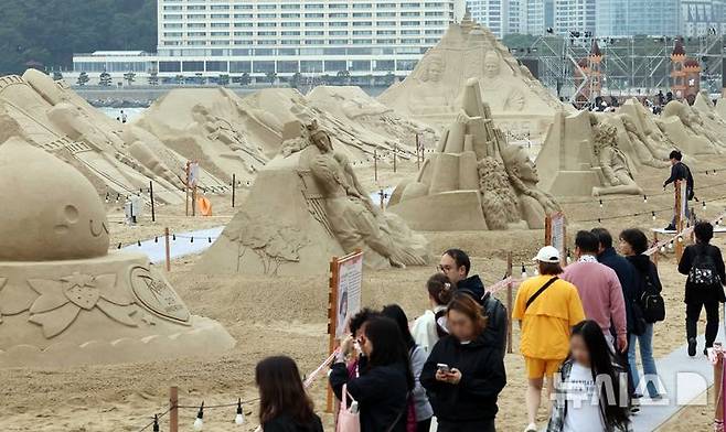 [부산=뉴시스] 하경민 기자 = 15일 부산 해운대구 해운대해수욕장을 찾은 시민과 관광객들이 다양한 모래조각 작품을 구경하고 있다. 해운대구는 오는 16~19일 '2025년 해운대 모래축제'를 개최한다. 올해 20주년을 맞은 모래축제는 '모래로 만나는 K-컬처'를 주제로 14명의 해외 모래 작가가 제작한 총 20여 개의 작품을 선보인다. 모래작품들은 축제 기간 이후인 오는 6월8일까지 전시될 예정이다. 2025.05.15. yulnetphoto@newsis.com