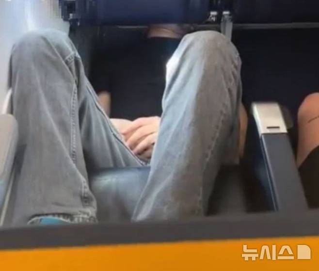 [서울=뉴시스] 항공기 의자에 거꾸로 누워서 잠을 자는 한 승객의 영상이 공개돼 화제다. (사진=틱톡 캡처)