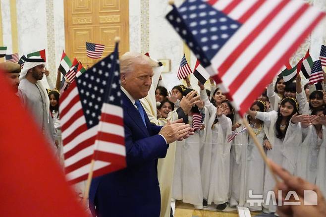 [아부다비=AP/뉴시스] 도널드 트럼프 미국 대통령이 셰이크 무함마드 빈 자이드 알나하얀 아랍에미리트(UAE) 대통령과 함께 15일(현지 시간) 아부다비의 카사르 알와탄 대통령궁에 도착해 어린이들의 환영을 받고 있다. 2025.05.16.