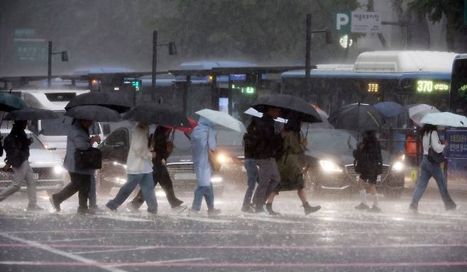 비가 내린 16일 서울 광화문사거리에서 시민들이 우산을 쓴 채 이동하고 있다. 연합뉴스