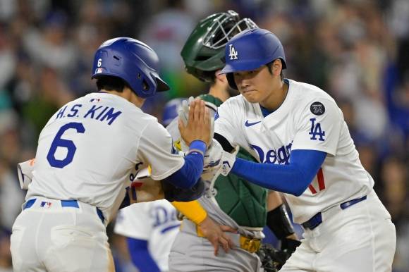 LA 다저스 김혜성이 16일(한국시간) 미국 캘리포니아주 로스앤젤레스 다저스타디움에서 열린 2025 미국프로야구 메이저리그(MLB) 애슬레틱스와의 홈 경기에서 2점 홈런을 친 오타니 쇼헤이와 하이파이브하고 있다. 로이터 연합뉴스