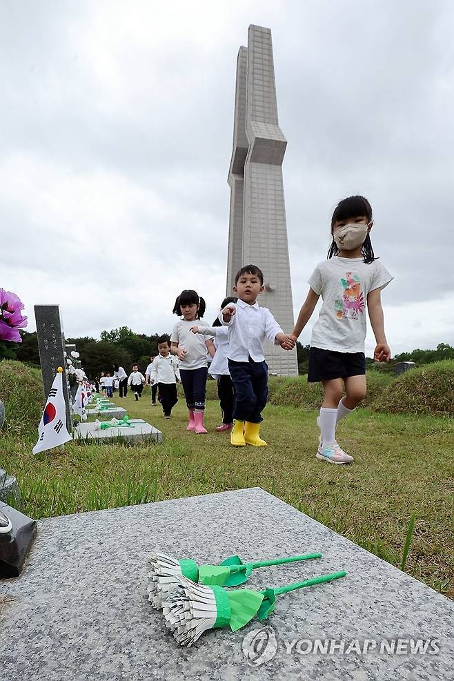 추모의 마음 담아 만든 우유팩 국화 (광주=연합뉴스) 김혜인 기자 = 5·18민주화운동 45주년을 이틀 앞둔 16일 광주 북구 운정동 국립5·18민주묘지에서 인양유치원 아이들이 우유팩으로 만든 국화를 헌화한 후 이동하고 있다. 2025.5.16 in@yna.co.kr