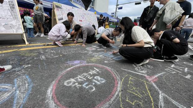 17일 광주시 동구 금남로에서 열린 5·18 전야제 시민난장 행사장에서 시민들이 금남로 바닥에 분필로 그림을 그리고 있다.