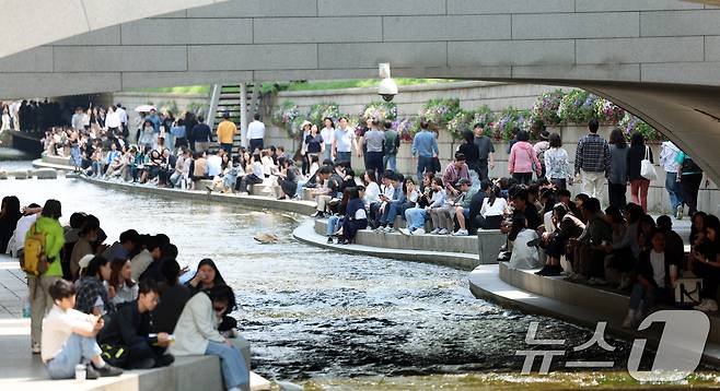 13일 서울 청계천에서 직장인들이 점심시간을 이용해 그늘에서 휴식을 취하고 있다. 2025.5.13/뉴스1 ⓒ News1 김명섭 기자