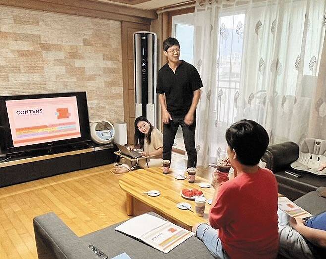 이지원(맨 왼쪽)·김민호(가운데)씨 부부가 양가 상견례를 앞둔 2023년 10월 서울 중랑구의 이씨 친정집에서 거실 TV에 자료를 띄워 결혼 계획을 설명하고 있다. /이지원씨 제공