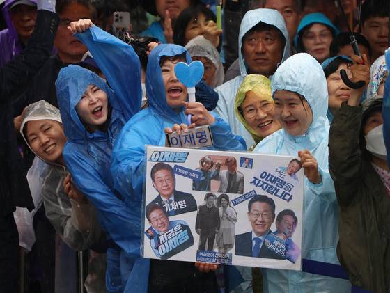 전국적으로 비가 내린 16일 각 당의 대선후보들은 유권자들을 찾아가 지지를 호소했다. 이날 이재명 민주당 대선후보의 연설회가 열린 전주시 전북대 후문 앞에서 시민들이 이 후보의 사진을 들고 환호하고 있다. 김성룡 기자