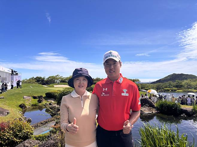 ‘골프계 우영우’로 불리는 이승민 프로가 어머니 박지애 씨와 함께 핀크스 골프 클럽 18번 홀에서 엄지를 치켜들고 있다.