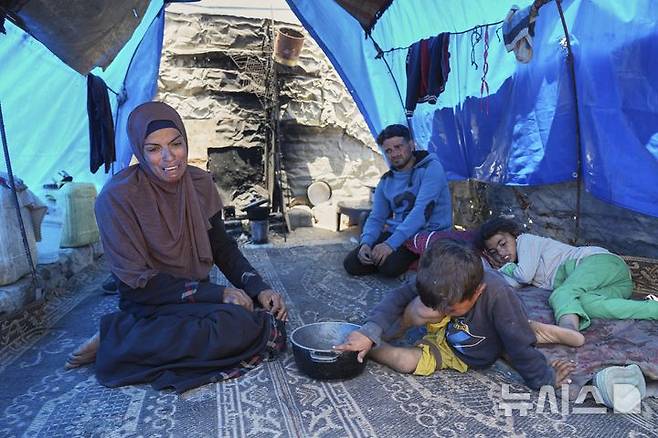 [칸유니스=AP/뉴시스] 9일(현지 시간) 가자지구 남부 칸유니스의 난민 텐트에서 음식 배급을 받지 못하고 빈손으로 돌아온 팔레스타인 여성이 가족들이 보는 앞에서 취재 기자에게 하소연하고 있다. 2025.05.10.