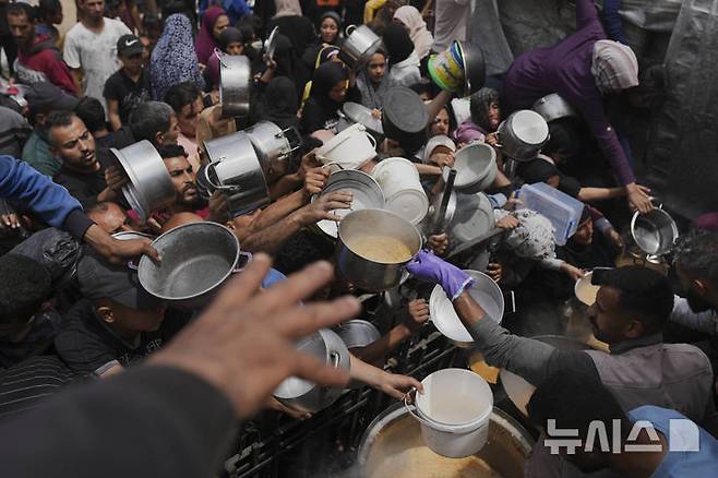 [자발리아=AP/뉴시스] 15일(현지 시간) 가자지구 북부 자발리아의 한 급식소에 팔레스타인 주민들이 음식을 배급받기 위해 몰려들고 있다. 유엔 세계식량계획(WFP)은 가자지구 내 대부분 빵집이 문을 닫았고, 자선 급식소들 또한 운영을 중단했으며, 식량 재고가 모두 소진돼 기근이 임박했다고 경고했다. 2025.05.16.