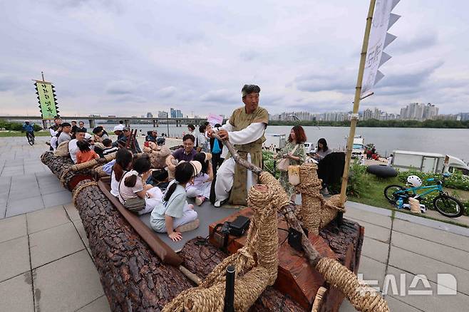 [서울=뉴시스] 김근수 기자 = '정선아리랑 in Seoul'이 열린 17일 서울 여의도 물빛광장에서 시민들이 뗏목 체험을 하고 있다. 2025.05.17. ks@newsis.com