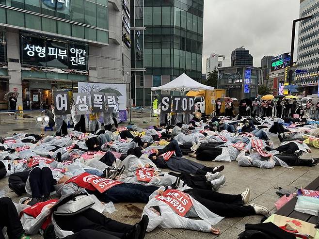 [서울=뉴시스] 이태성 기자 = '강남역 살인사건' 9주기를 맞은 17일 오후 서울 서초구 강남역 10번출구 앞에서 열린 추모행동 집회 '우리는 지금보다 더 강하게!' 참가자들이 다이-인(Die-in) 퍼포먼스를 통해 여성폭력에 희생된 여성들의 죽음을 추모했다. 2025.05.17. victory@newsis.com *재판매 및 DB 금지