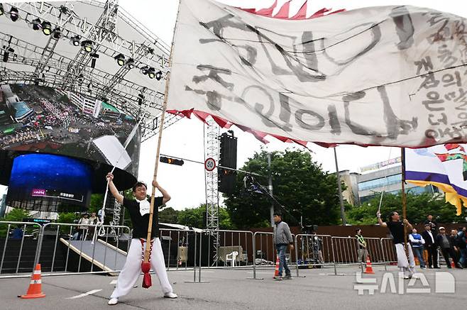[광주=뉴시스] 이영주 기자 = 17일 오후 광주 동구 금남로에서 5·18민주화운동 45주기를 기념하는 풍물패가 '국민이 주인이다' 글귀가 쓰인 대형 깃발을 흔들고 있다. 2025.05.17. leeyj2578@newsis.com