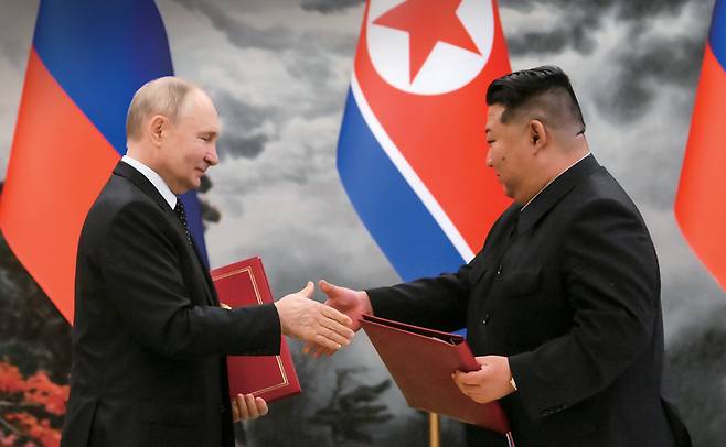 2024년 6월19일 북한 평양에서 열린 새로운 협력 관계 체결 서명식에서 블라디미르 푸틴 러시아 대통령(왼쪽)과 북한 김정은 국무위원장이 문서를 교환하고 있다. ⓒAP 연합