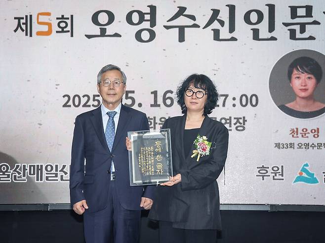 우보 배성근 서예가를 대신해 도홍진 전 울산과학대 교수가 천운영 수상자에게 그녀의 수상작인 '등에 쓴 글자'를 담은 축하 휘호를 전달하고 있다. 이수화 기자