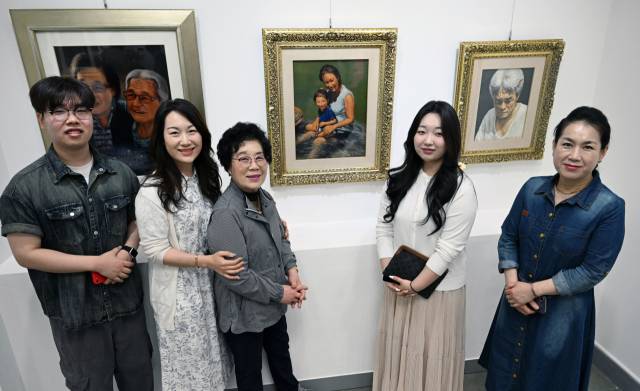 지난 16일 고 배창노 화백 초대전이 열린 창원시 성산구 경남교육청 제2청사 갤러리에서 배 화백의 아내 김신지씨 등 유족들이 작품을 배경으로 기념사진을 찍고 있다./김승권 기자/