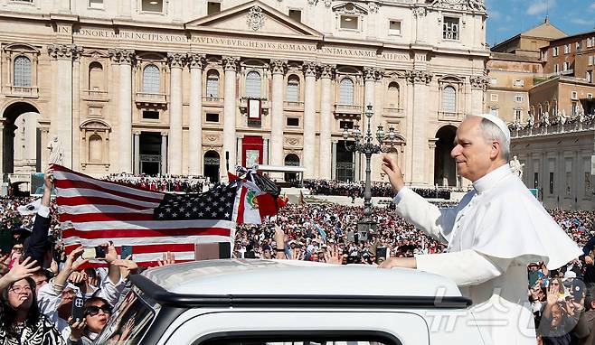 교황 레오 14세가 바티칸 성 베드로 광장에서 열린 즉위 미사에 앞서 포프모빌(교황 전용차량)에서 신자들에게 손을 흔드는 동안 미국 성조기가 들어 올려져 있다. 2025.5.18ⓒ 로이터=뉴스1 ⓒ News1 신기림 기자