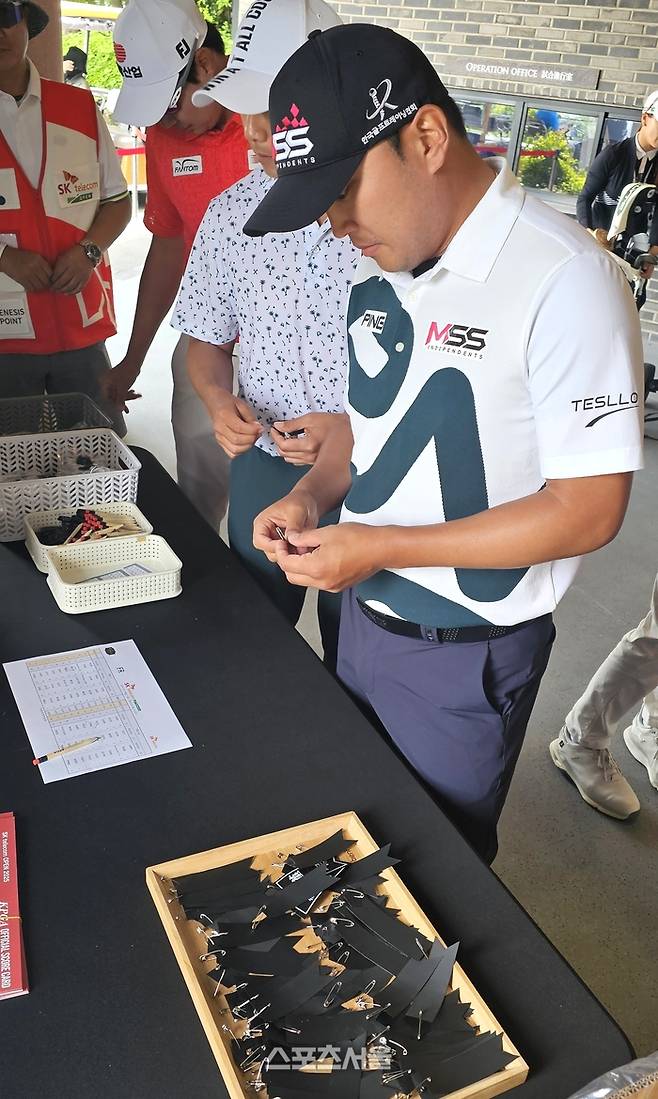 황도연이 18일 KPGA투어 SK텔레콤 오픈 최종라운드를 앞두고 고(故) 박병주를 추모하는 근조 리본을 집어들고 있다. 사진 | 서귀포=장강훈 기자 zzang@sportsseoul.com