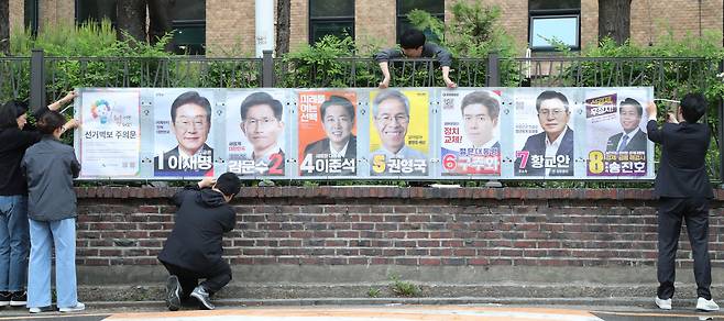 서울시선거관리위원회 관계자들이 지난 15일 서울 종로구 예술가의 집 담장에 제21대 대통령선거 선거 벽보를 부착하고 있다. 선거 벽보는 이날부터 전국 8만2900여 곳에 첩부된다. /장경식 기자