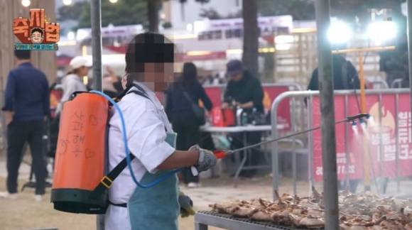 한 지역 축제 현장에서 농약분무기통에 사과주스를 담아 음식에 뿌리는 모습. [사진=백종원 유튜브]