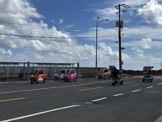 지난해 10월 제주도 섬속의 섬 우도를 찾은 관광객들이 전기 카트와 오토바이를 타고 해안도로를 달리고 있다. 최충일 기자