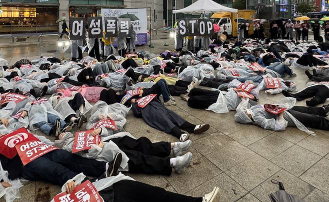 95개 여성시민단체 참가자들이 17일 오후 6시 서울 지하철 2호선 강남역 10번 출구 앞에서 ‘여성폭력 스톱(STOP)’이라고 적힌 손팻말을 들고 ‘다이인’(die-in·죽은 것처럼 드러눕는 시위) 퍼포먼스를 하고 있다. 사진 장보인, 연합뉴스