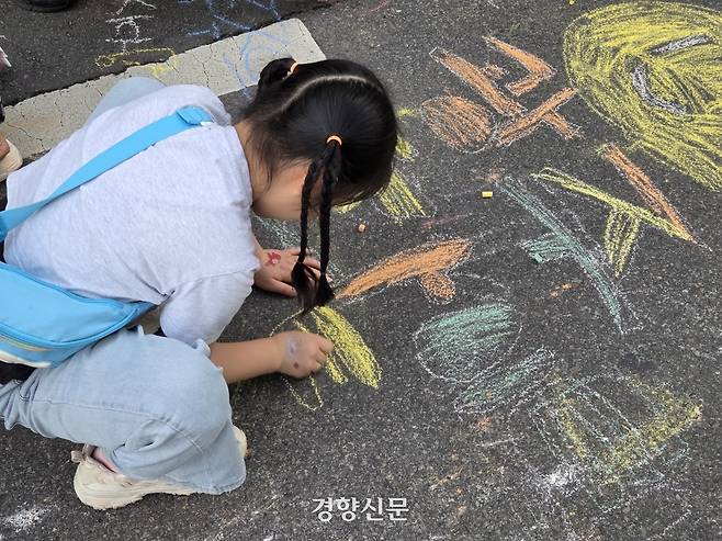 지난 17일 광주 동구 금남로에서 열린 5·18전야제에서 한 어린이가 아스팔트 바닥에 분필로 ‘광주 화이팅’이라고 쓰고 있다. 우혜림 기자