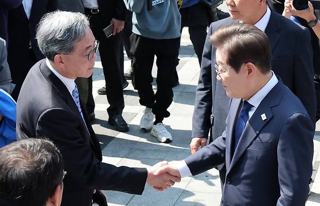 Democratic Party candidate Lee Jae-myung, right, shakes hands with his foreign policy aide Kim Hyun-jong, left, at Cheonggye Square in central Seoul on May 12. [KIM SEONG-RYONG]