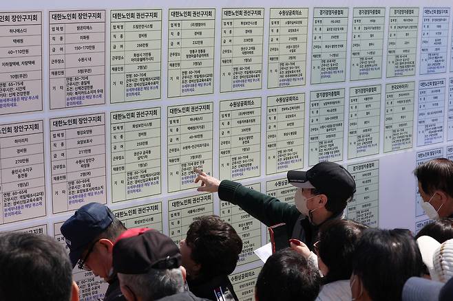 Job seekers 60 and older view job postings during the 17th Senior Job Fairat Hwaseong Haenggung Square in Paldal District, Suwon, Gyeonggi, on March 28. [NEWS1]