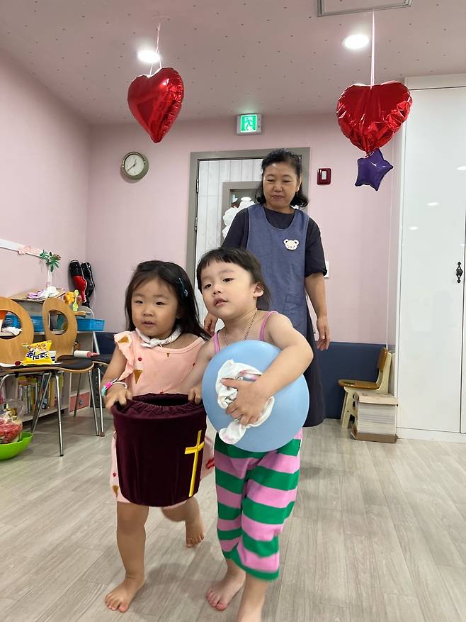 화평교회 이광희 집사가 2023년 7월 영아부실에서 헌금안내위원으로 봉사하는 아이들을 돕고 있다.