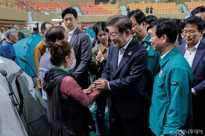 [광주=뉴시스] 조성우 기자 = 이재명 더불어민주당 대선후보가 17일 광주 광산구 광주여자대학교 유니버시아드 체육관에 마련된 금호타이어 공장 화재 대피소를 찾아 이재민을 위로하고 있다. (공동취재) 2025.05.17. photo@newsis.com /사진=