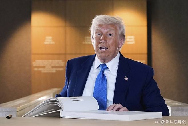 [아부다비(아랍에미리트)=AP/뉴시스]도널드 트럼프 미 대통령이 16일 아랍에미리트(UAE) 아부다비의 있는 아브라함 가옥을 둘러본 뒤 방명록에 서명하고 있다. 그는 이날 집권 2기 핵심 목표 중 하나인 이란과의 핵협상이 임박했다고 밝혔다고 뉴욕 타임스(NYT)가 보도했다. 2025.05.16. /사진=유세진