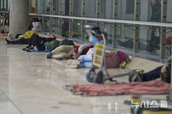 [마드리드=AP/뉴시스] 15일(현지 시간) 스페인 마드리드의 아돌포 수아레스 마드리드-바라하스 공항 4터미널 바닥에서 사람들이 잠을 자고 있다. 공항 당국은 터미널 내에 증가하는 노숙자 문제로 일부 시간대에 탑승권이 없는 사람들의 출입을 제한할 것으로 전해졌다. 2025.05.16.